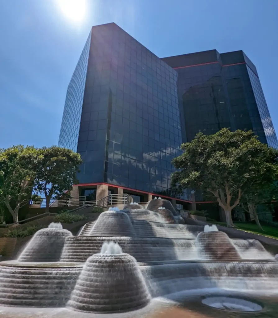 Exterior of ReviewInc headquarters at 21800 Oxnard Street featuring a modern office building with water fountain.