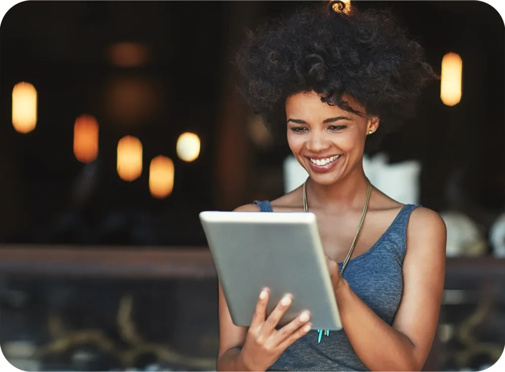 Smiling woman using a tablet to connect with ReviewInc for reputation management services.