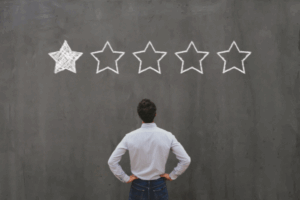 Person looking at a one-star rating on a chalkboard wall, representing how businesses deal with bad reviews from customers.