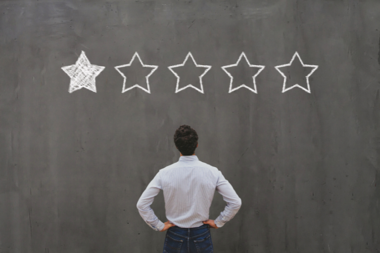 Person looking at a one-star rating on a chalkboard wall, representing how businesses deal with bad reviews from customers.