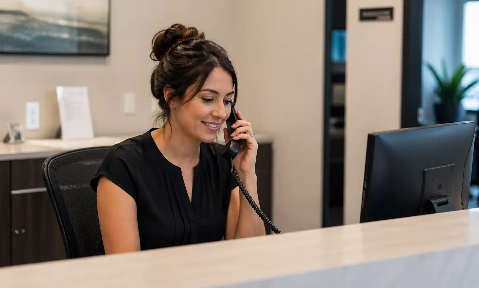 A receptionist on the phone simulating answering a Google business profile automated updates phone call verification